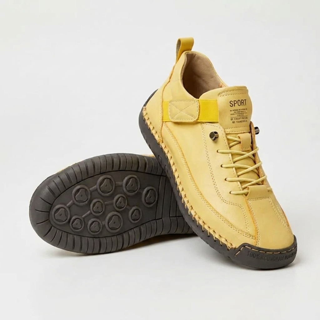 Yellow sneakers with a yellow elastic strap and dark sole, one shoe upright and one showing the tread 13