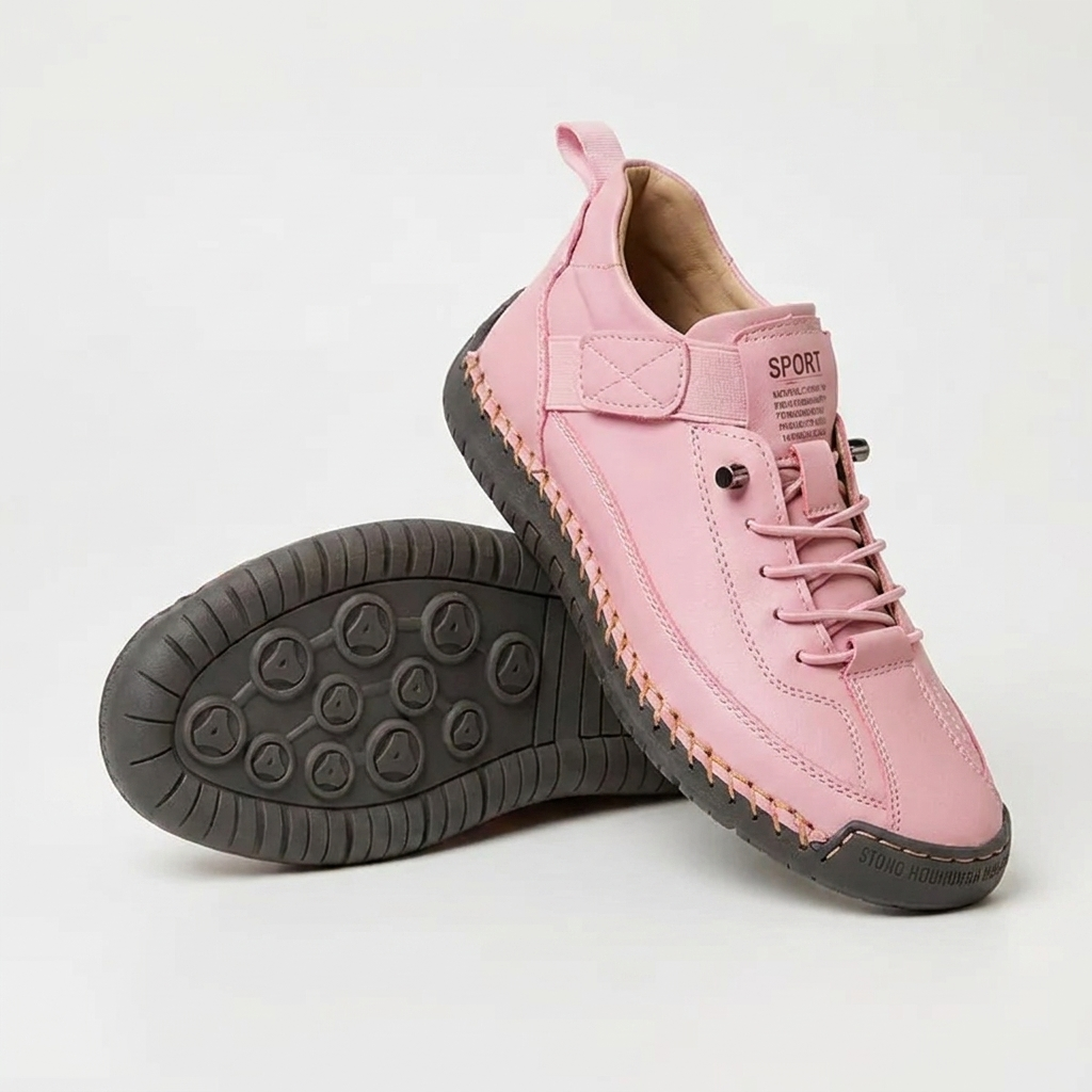 Pink sneakers with a dark gray stitched sole, one shoe standing and one flipped to show the tread 14