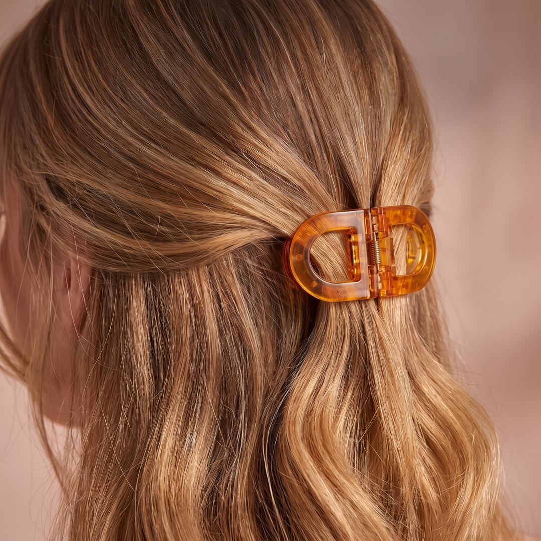 Close-up of a woman's wavy blonde hair gathered with an amber translucent Flat Grip Magnetic Hair Clip.