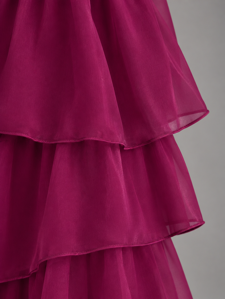 Close-up detail of the berry-colored sheer tiered ruffles with finely stitched hems. 23