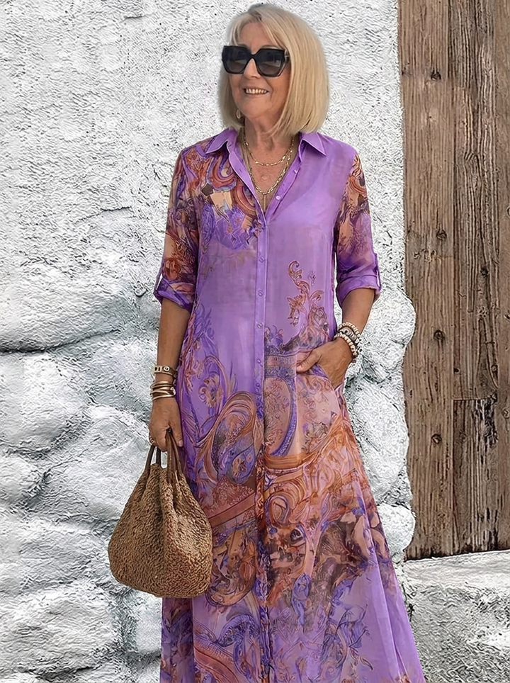 Purple version of the sheer button-front maxi dress with orange swirl print, worn with gold necklaces and a brown textured tote. 5