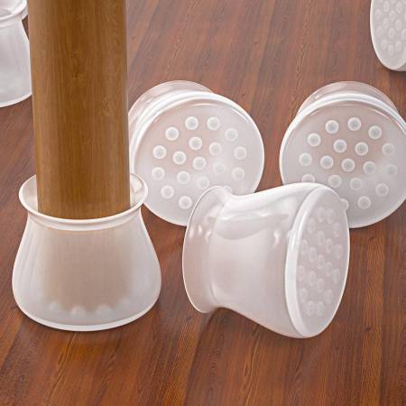 Wooden table leg fitted with a clear cap, beside loose caps showing dotted non-slip bases 2