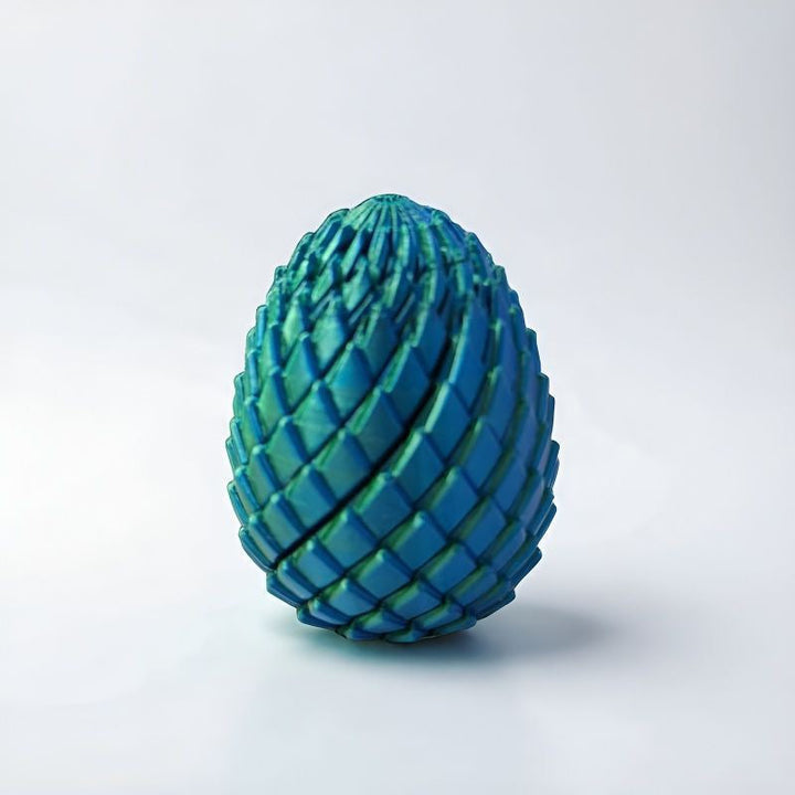 Teal and green scaled egg standing on a light gray background 11
