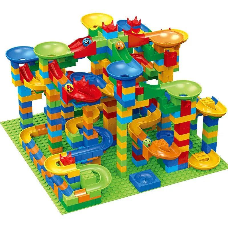 Large, tall marble run build with blue, green and yellow funnels, slides and smiley-faced balls on a big green baseplate.