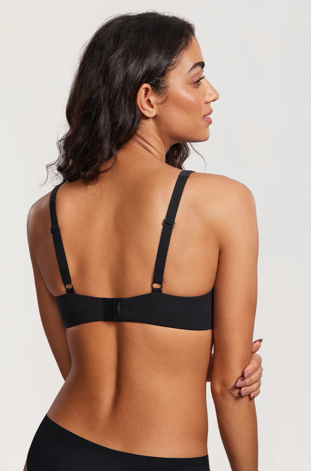 Back view of a black bra showing the adjustable straps and hook-and-eye closure.