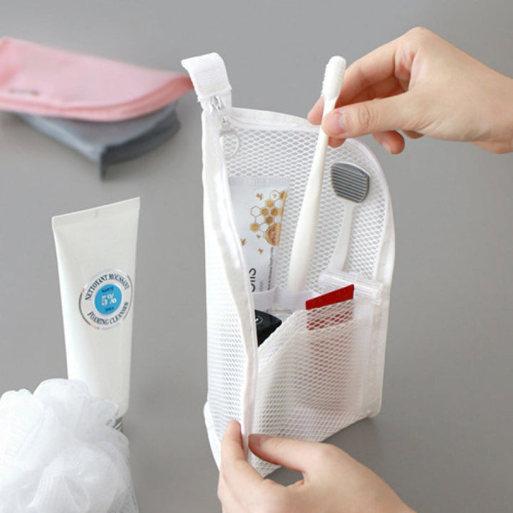 White EVA travel toiletry organizer pouch with compartments and a toothbrush, toothpaste and small items.
