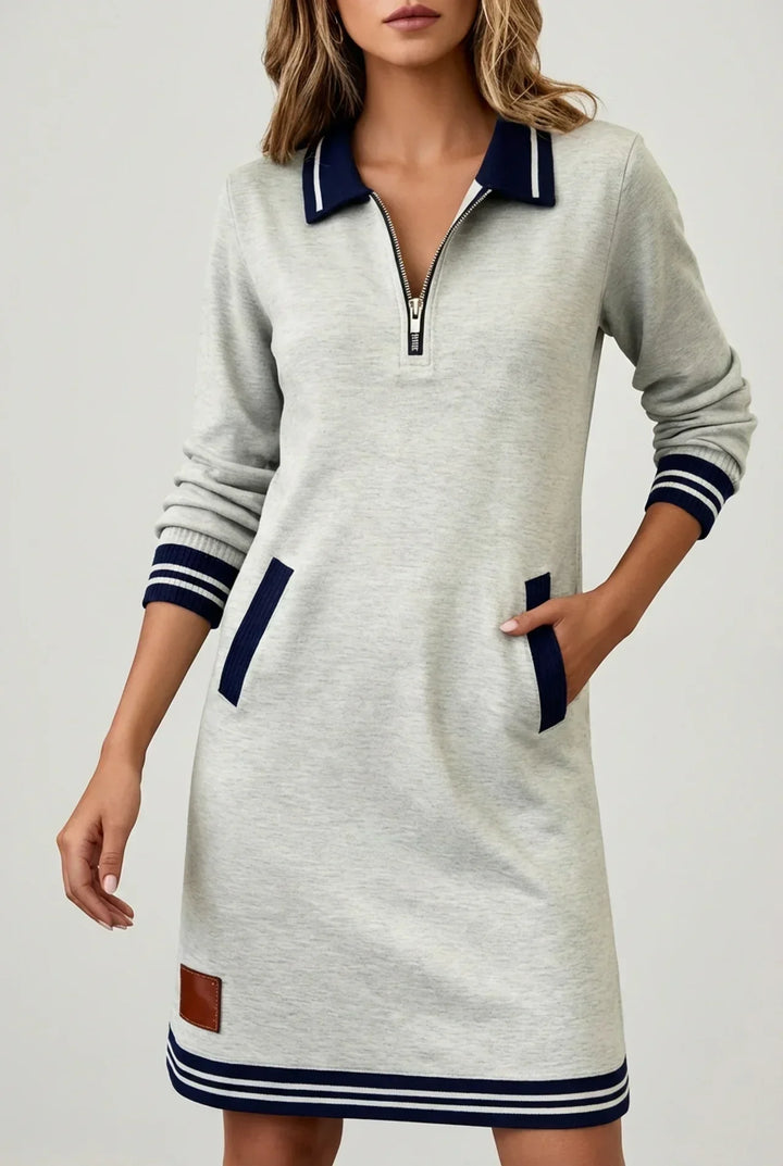 Light gray version on a model, hand in pocket, showing the half-zip collar, striped cuffs and brown patch at the hem. 7