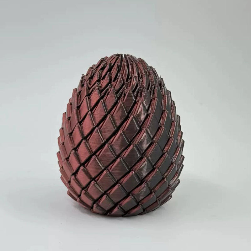 Dark metallic red scaled egg with a bronze sheen on a plain light backdrop 12