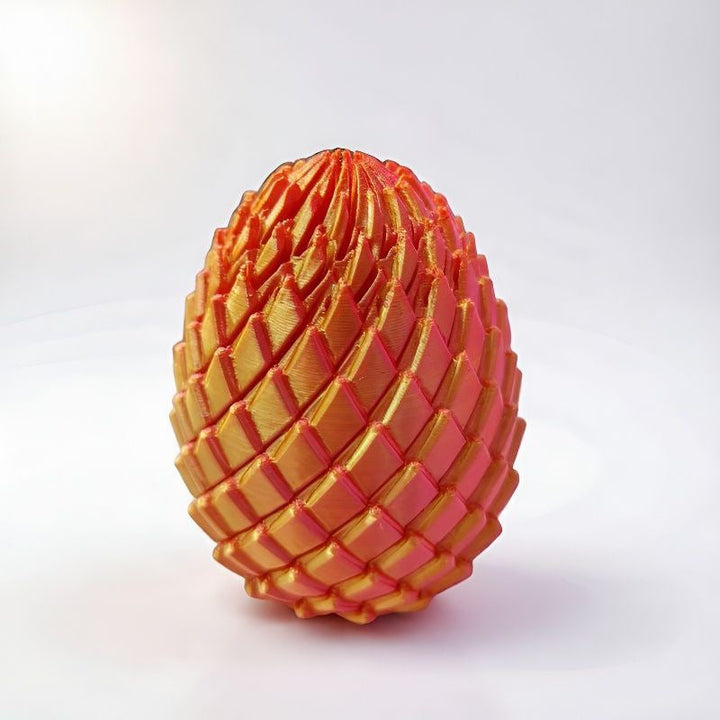 Orange and gold scaled egg standing upright on a white surface 9