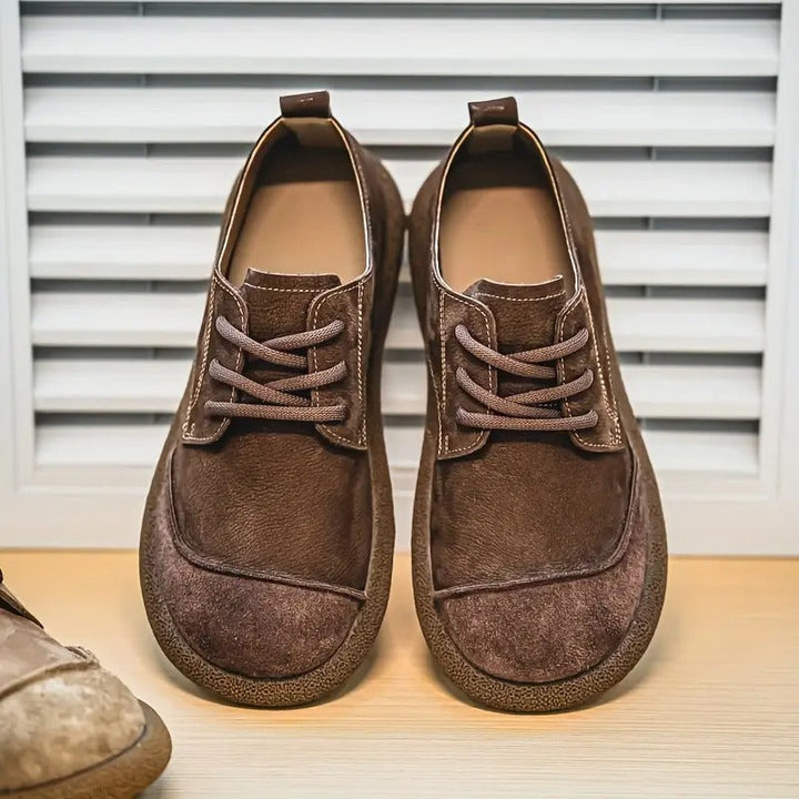 Pair of dark brown leather lace-up shoes with wide toe caps and crepe-style soles.