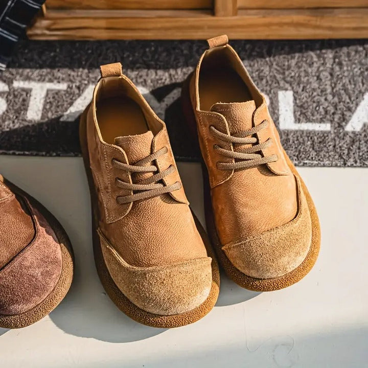 Brown leather lace-up shoes with rounded toe caps and tan soles, shown from above.