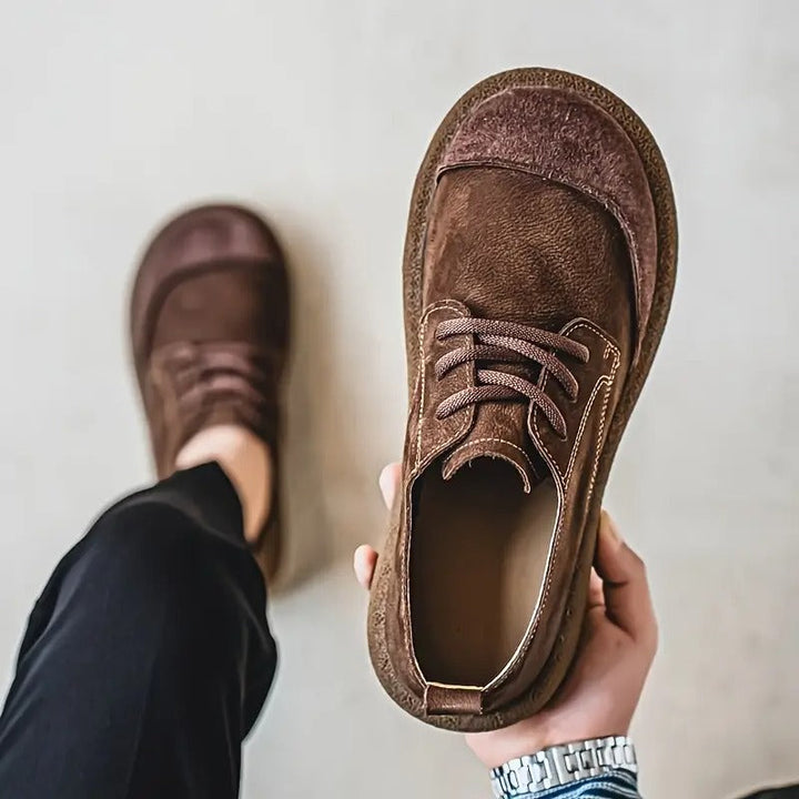 Dark brown leather lace-up shoes detail showing the interior and stitching.