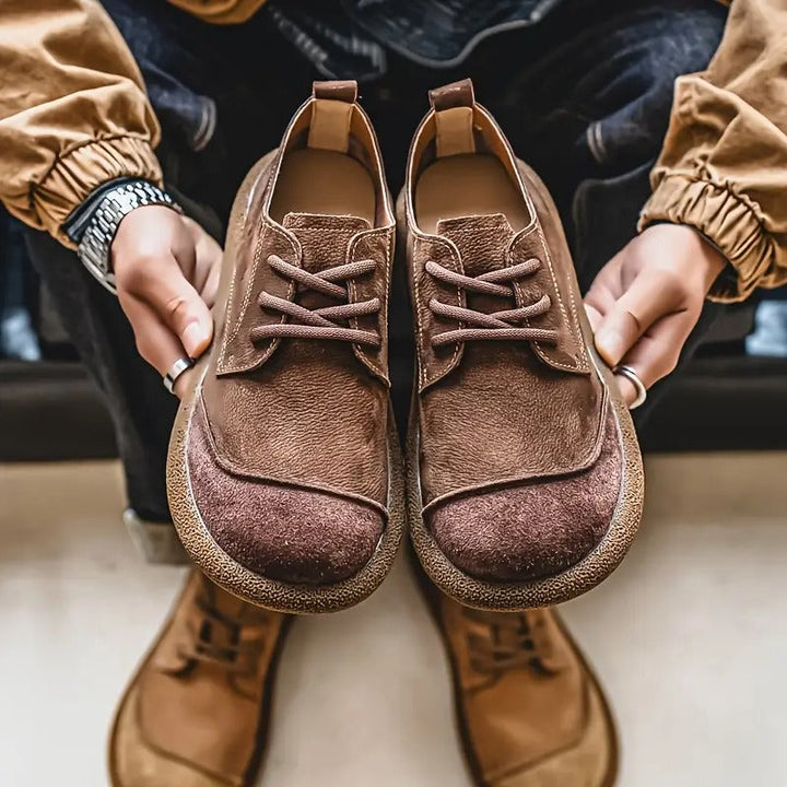 Pair of brown leather lace-up shoes with wide toe caps.
