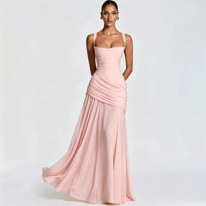 Model in a light pink maxi dress with square neckline, gathered waist drape and a flowing skirt