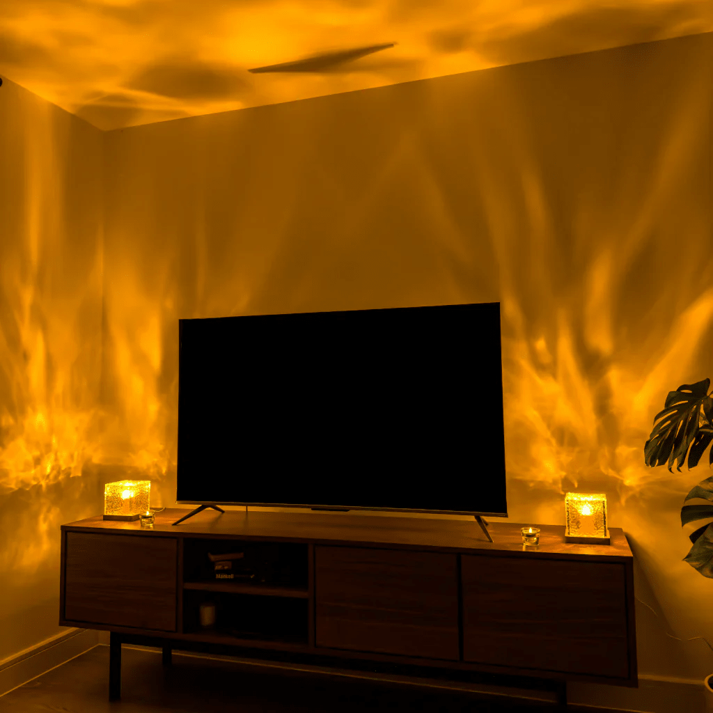 Two glowing cube lamps flank a flat-screen TV on a wooden media console, throwing warm golden light waves up the walls. 4