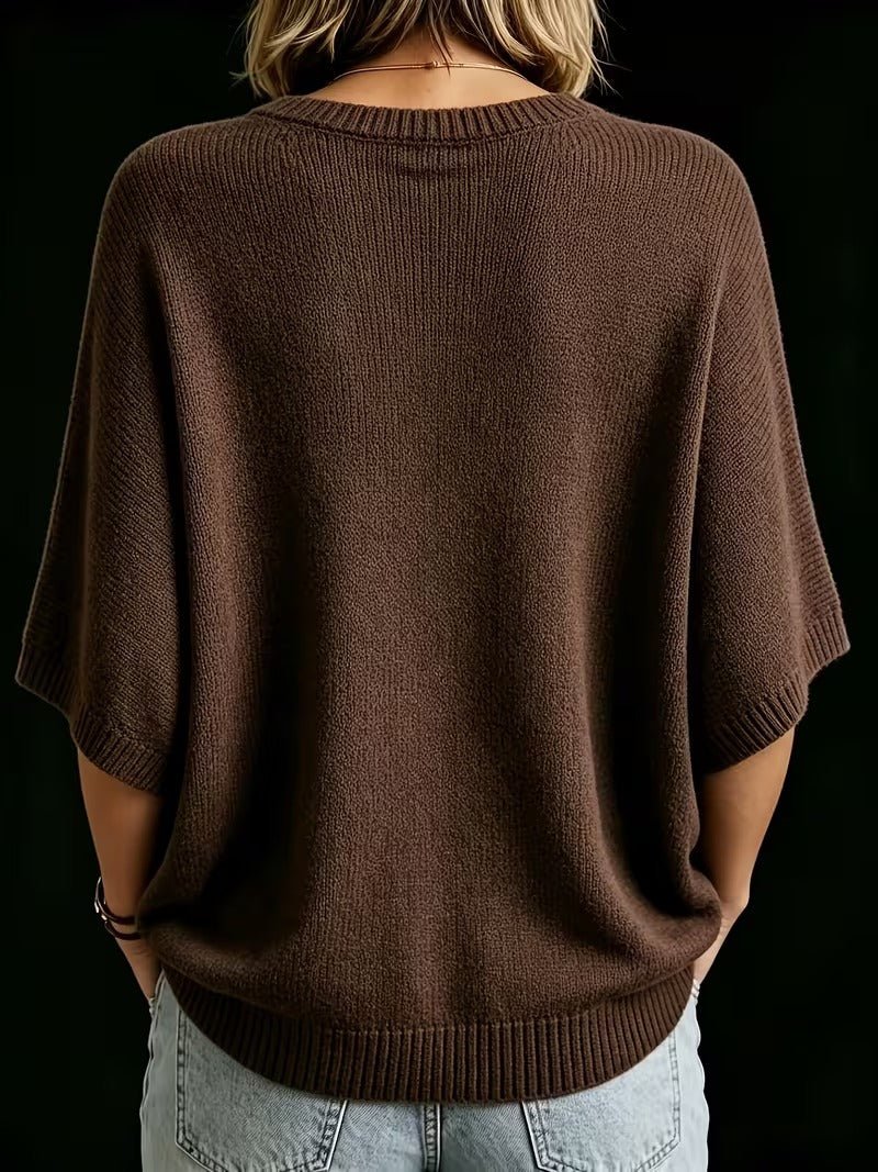Back view of the brown ribbed-knit batwing top worn with light jeans, showing the wide sleeves and ribbed hem. 21