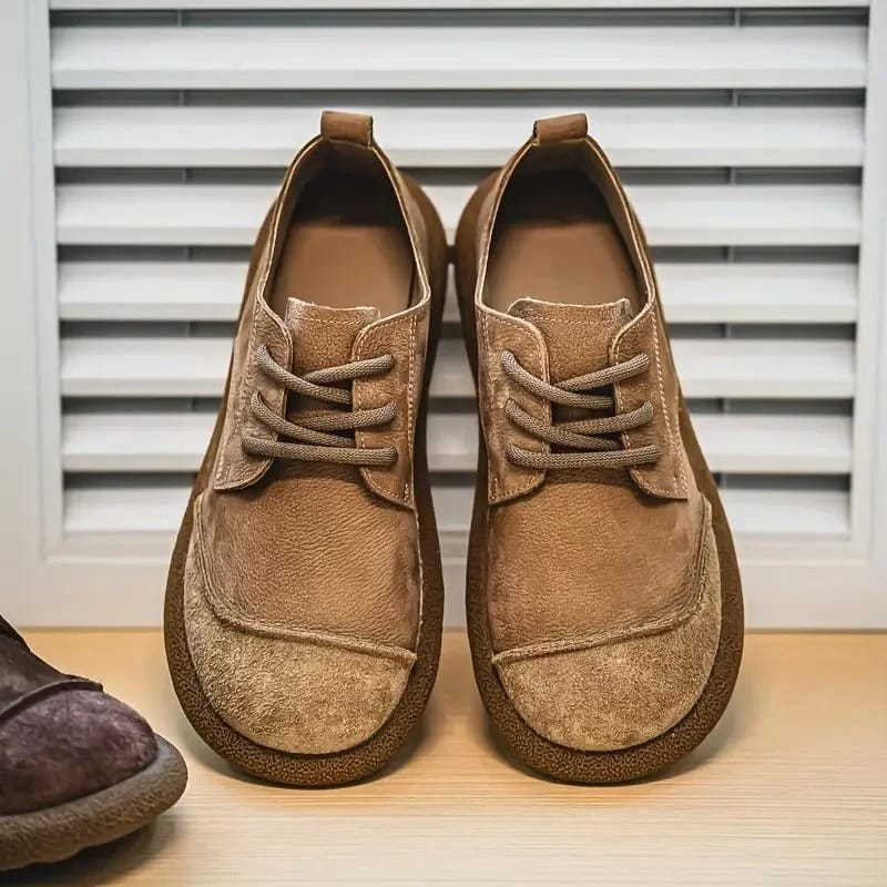 Tan lace-up pair on a wooden shelf by white shutters, a brown shoe at left 9