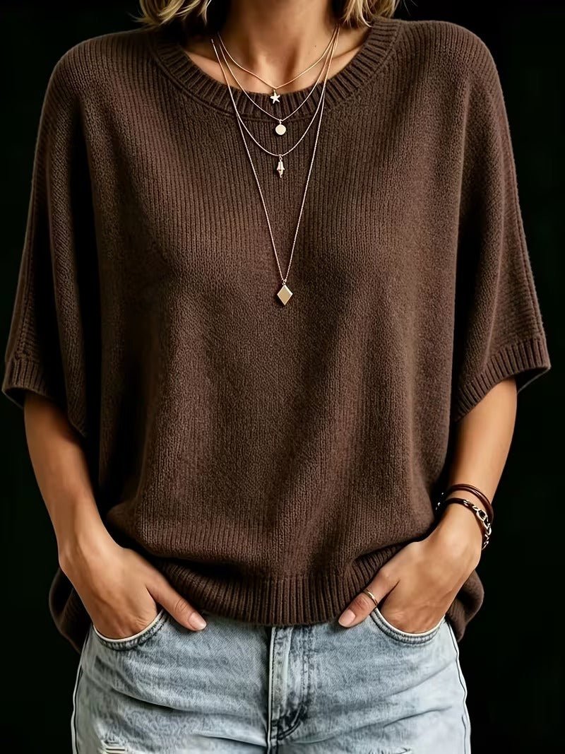 Dark brown knit top, front view with both hands in jeans pockets, showing ribbed neckline, sleeve cuffs and hem.