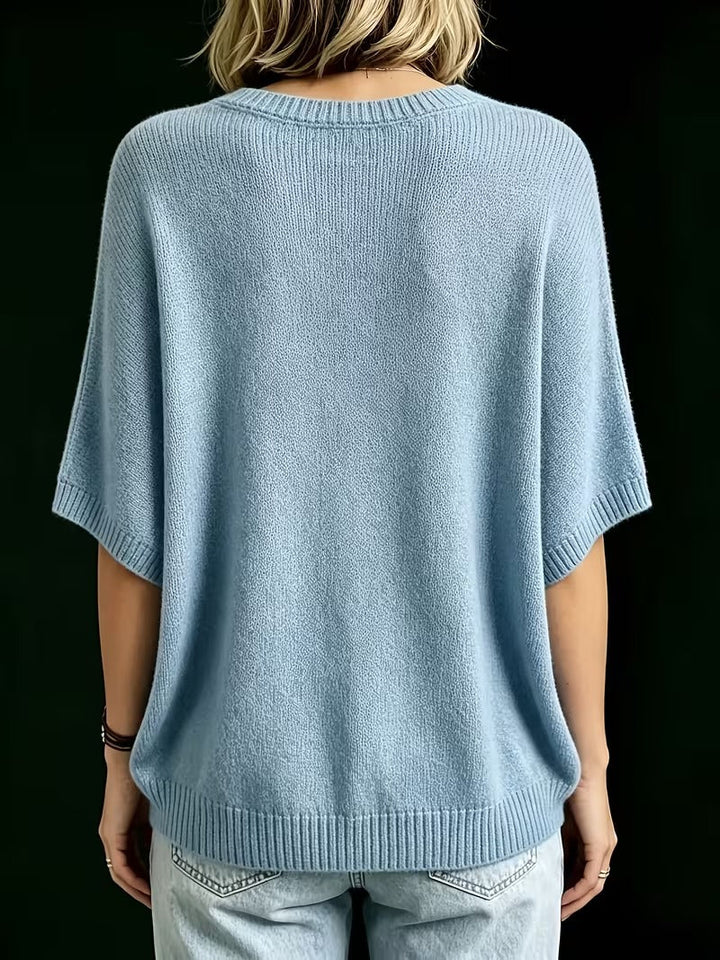 Light blue knit top, back view showing the ribbed neckline, batwing sleeves with ribbed cuffs and ribbed hem.