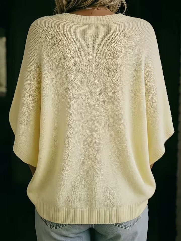 Pale yellow knit top, back view showing the ribbed neckline, wide batwing sleeves and ribbed hem.