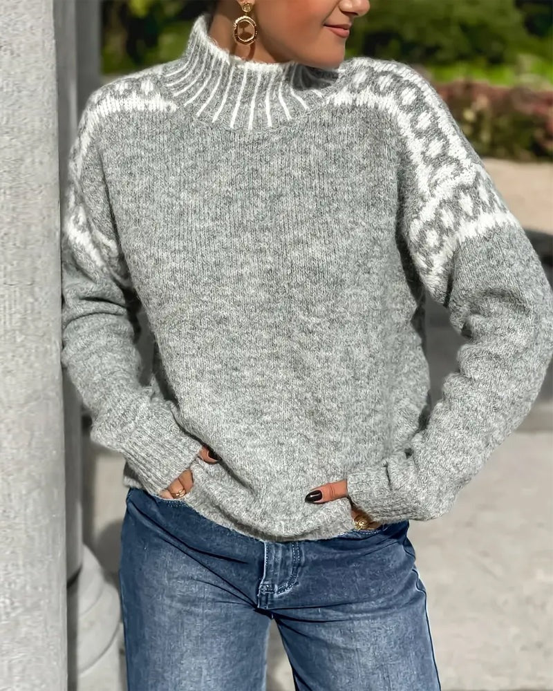 Gray knit mock-neck sweater with white patterned shoulders and striped collar, worn with blue jeans outdoors 5