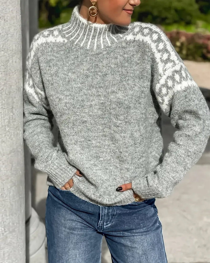 Gray knit mock-neck sweater with white patterned shoulders and striped collar, worn with blue jeans outdoors 5
