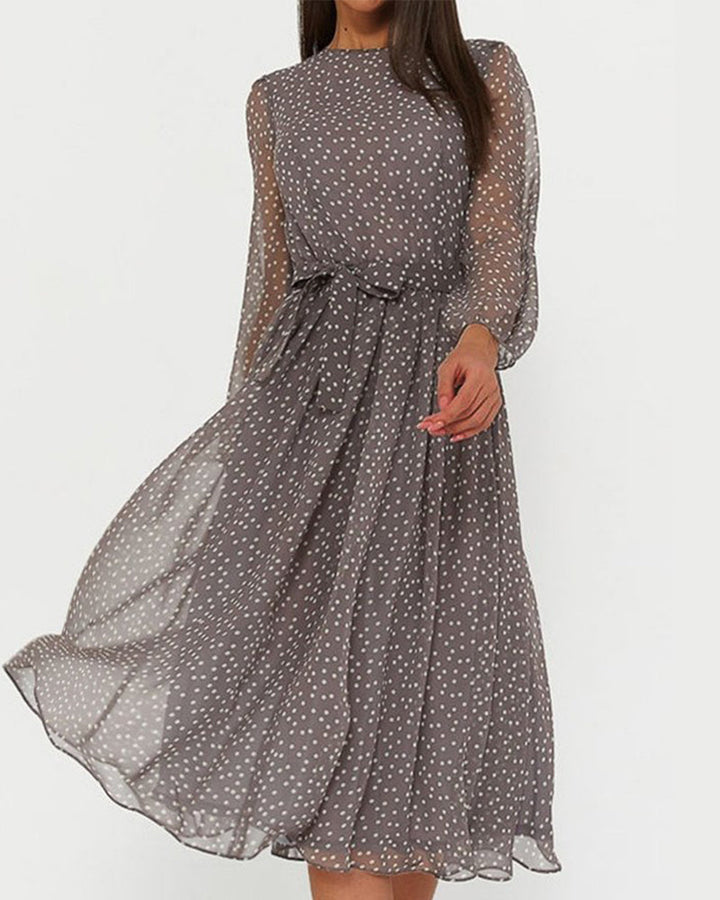 Gray polka dot dress with a tied waist belt, shown against a plain light studio background.