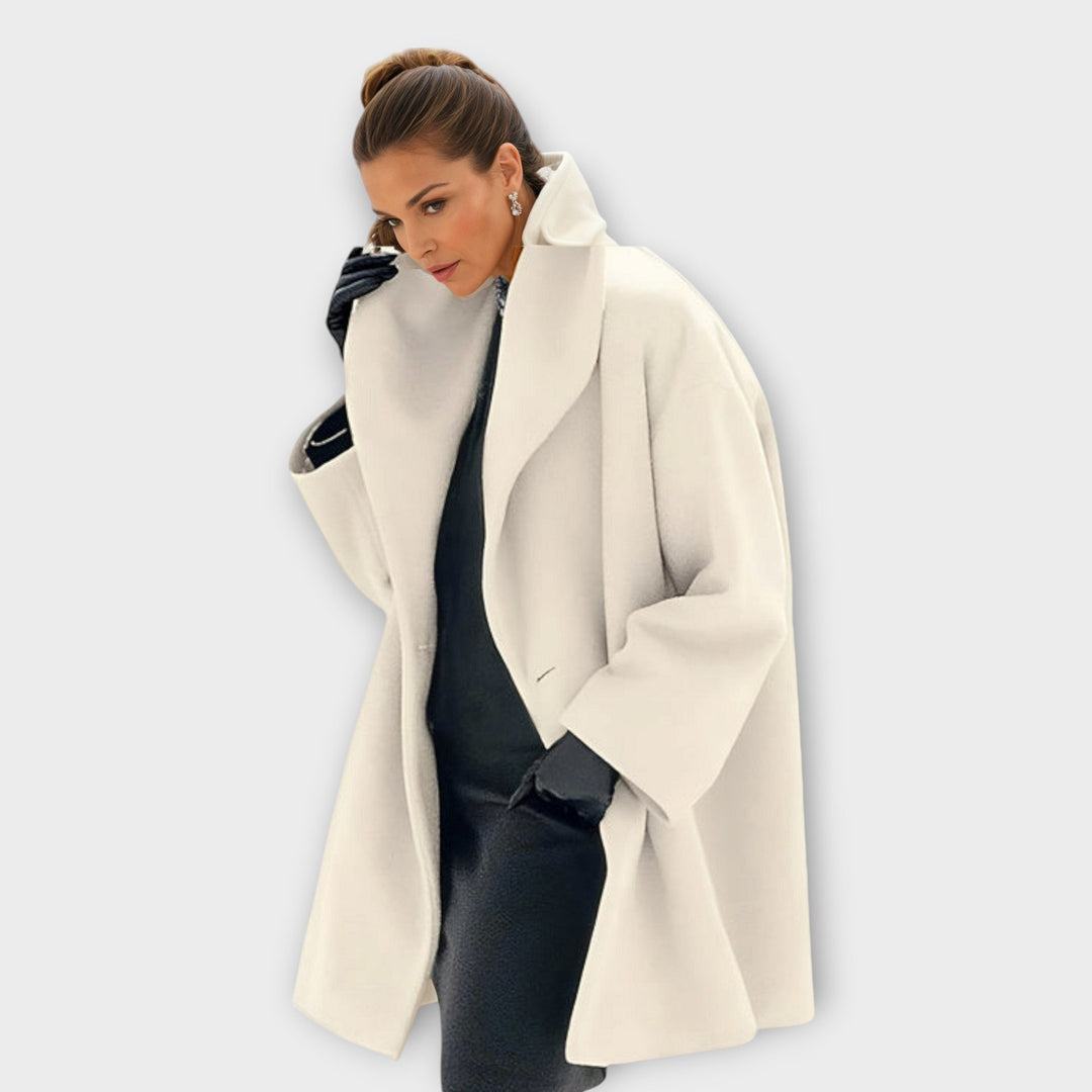 Woman in the cream white version of the coat with a high wide collar, styled over a black dress and black gloves. 6