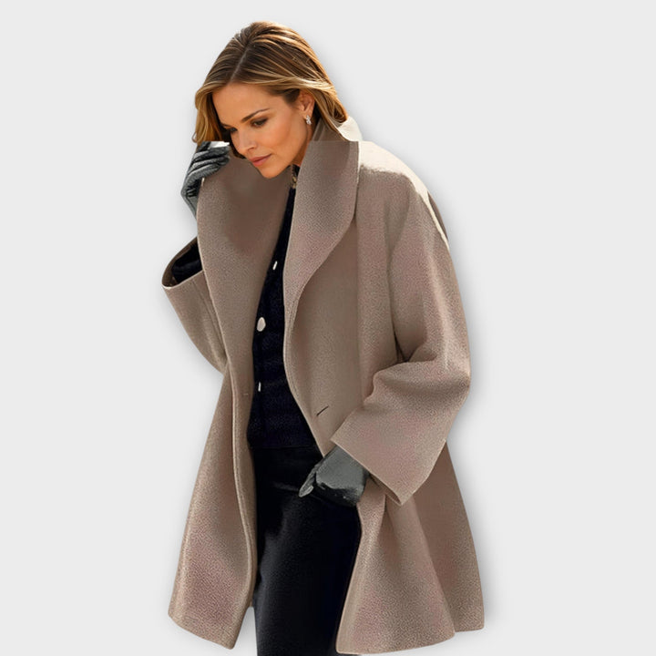 Woman in the relaxed coat in a soft taupe beige with a nubby wool-like texture, hand tucked in the pocket. 4