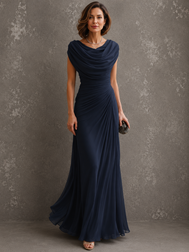 Model in the beige dress, with draped cowl neckline, ruched waist and floor-length skirt.