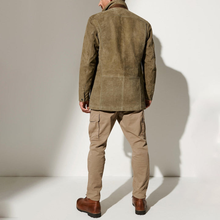 Back view of the suede jacket worn by a model with khaki cargo pants and brown boots, showing seamed panels. 3