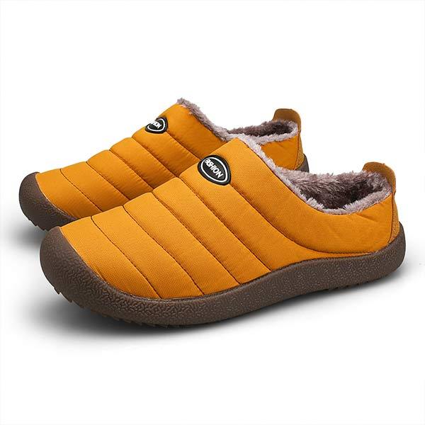 Pair of mustard orange quilted slippers with fleece lining and chunky dark brown soles on white 11