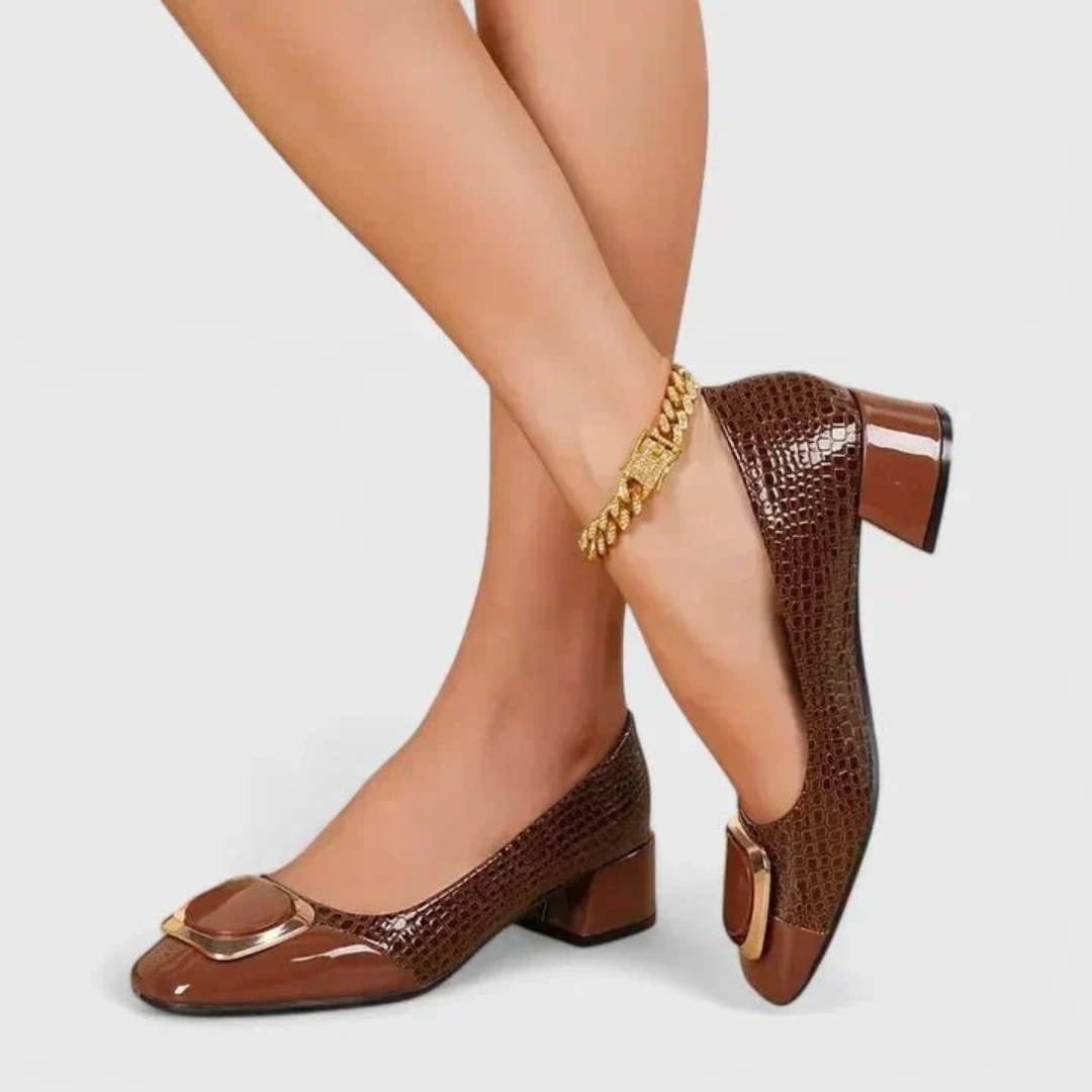 Model wearing brown croc-embossed block-heel shoes, another view of the gold buckle on the toe and the sturdy heel.