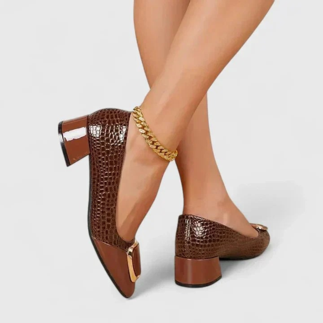 Model wearing brown croc-embossed block-heel shoes, detail of the back, glossy heel and side profile.