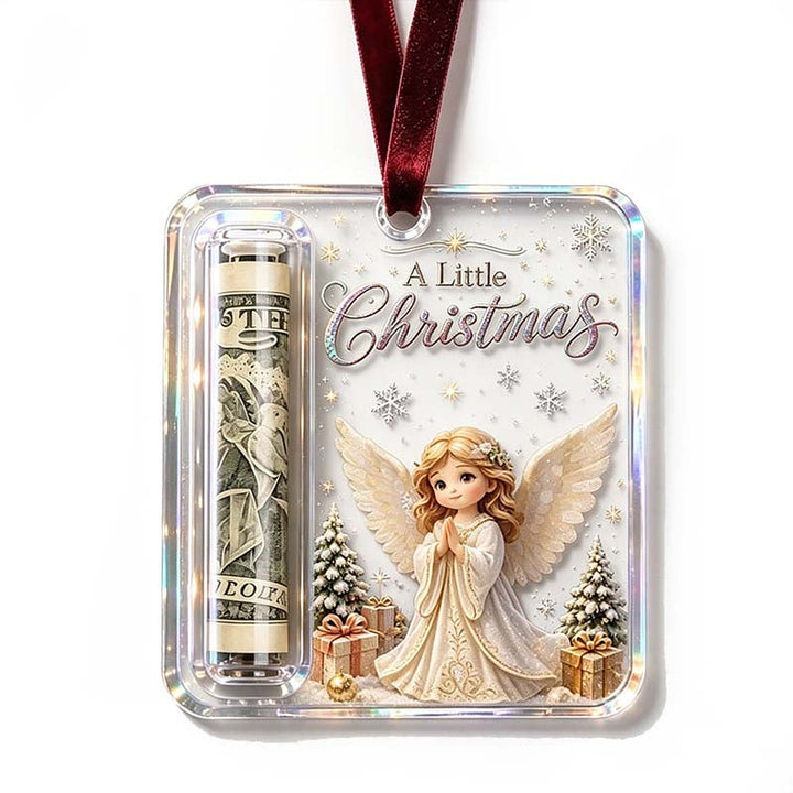 Angel design ornament with golden hair and cream wings among presents and snowy trees and a rolled bill in the slot.