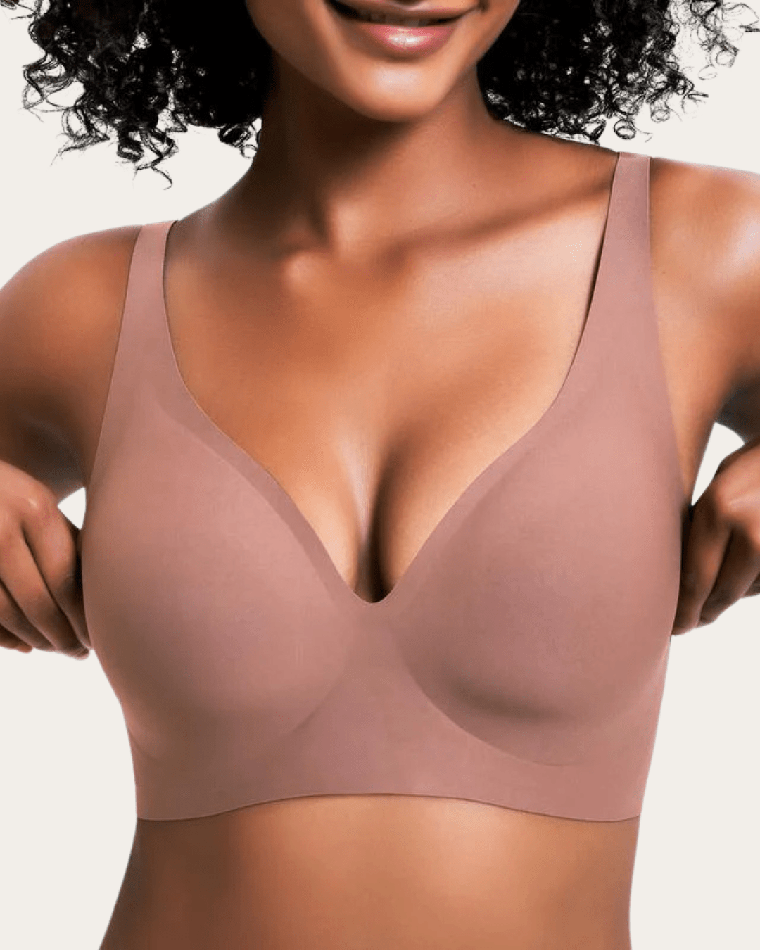 Model wearing the dusty rose brown seamless V-neck bra, adjusting the sides.