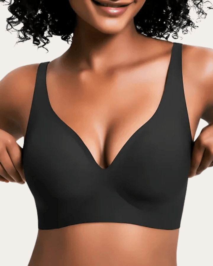 Model wearing the black seamless V-neck bra, adjusting the sides.