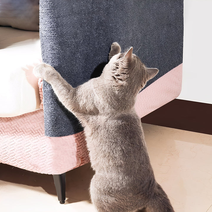 Gray cat standing on its hind legs and scratching a gray mat stuck to the armrest of a pink sofa. 2