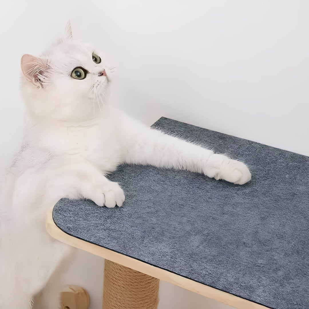 White cat resting its paws on a gray mat attached to a wooden cat shelf above a sisal post. 4