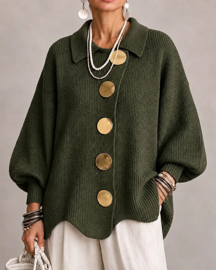 Dark olive green ribbed cardigan on a model with large gold buttons, pointed collar and balloon sleeves. 12