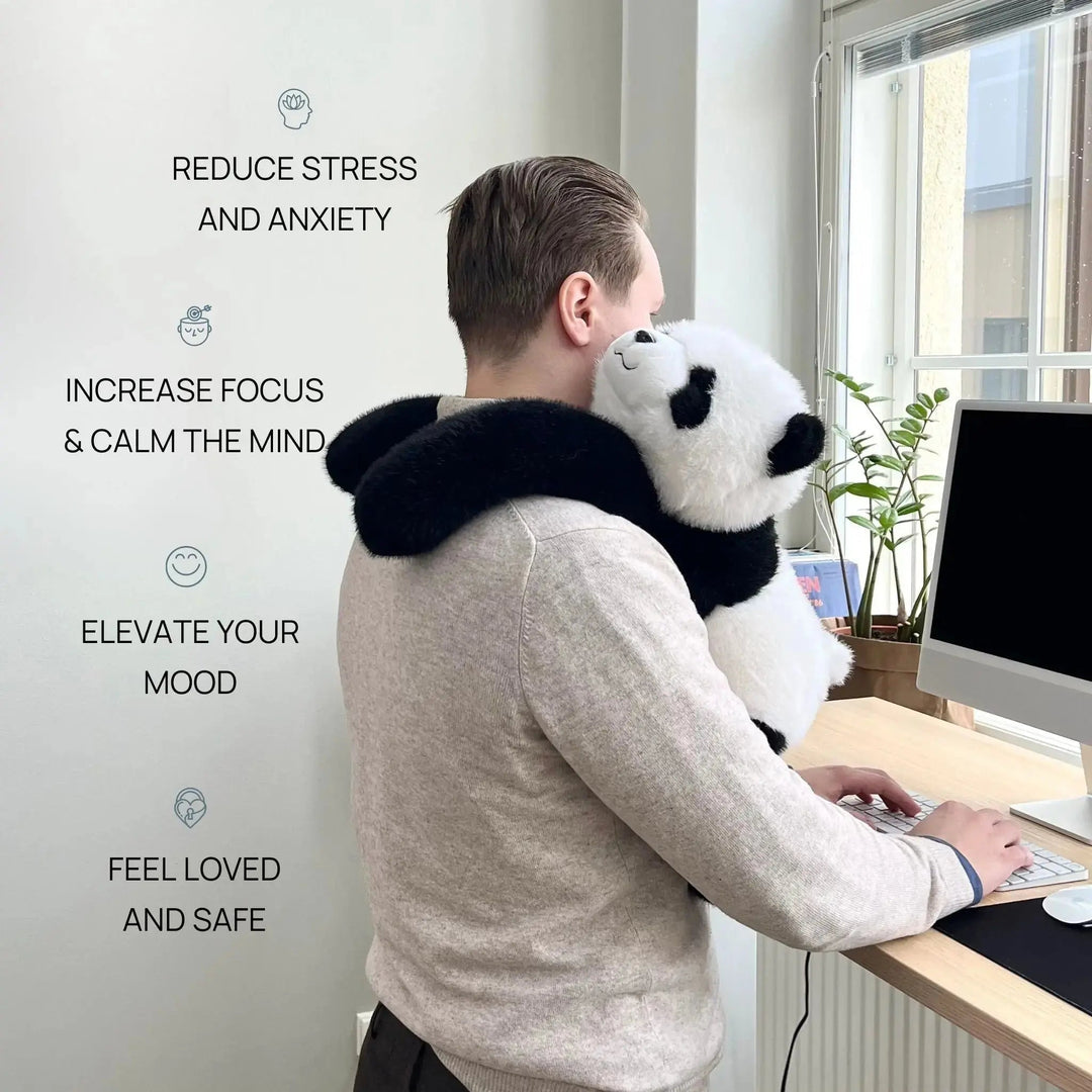 Man in a gray sweater typing at a standing desk with the panda draped over his shoulder, arms wrapped around his neck. 2