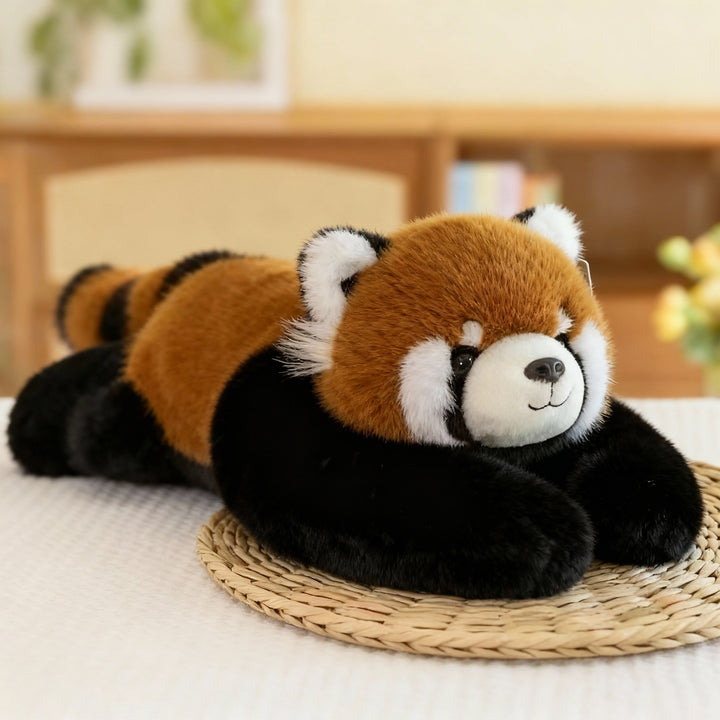 Red panda plush with rusty orange fur, white face markings and long black arms lying on a woven straw mat. 13