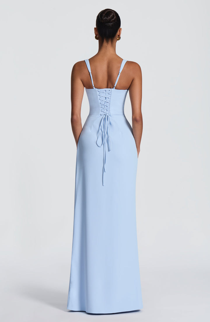 Back view of the light blue gown on a model, showing the corset-style lace-up back, thin adjustable straps and long dangling ties. 25