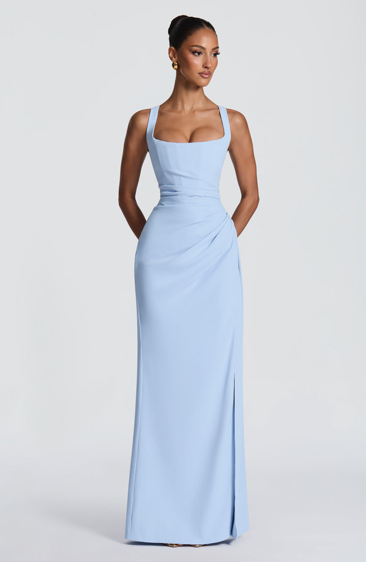 Front view of the light blue gown on a model with the slit closed, showing the draped, gathered hip and floor-length skirt. 27