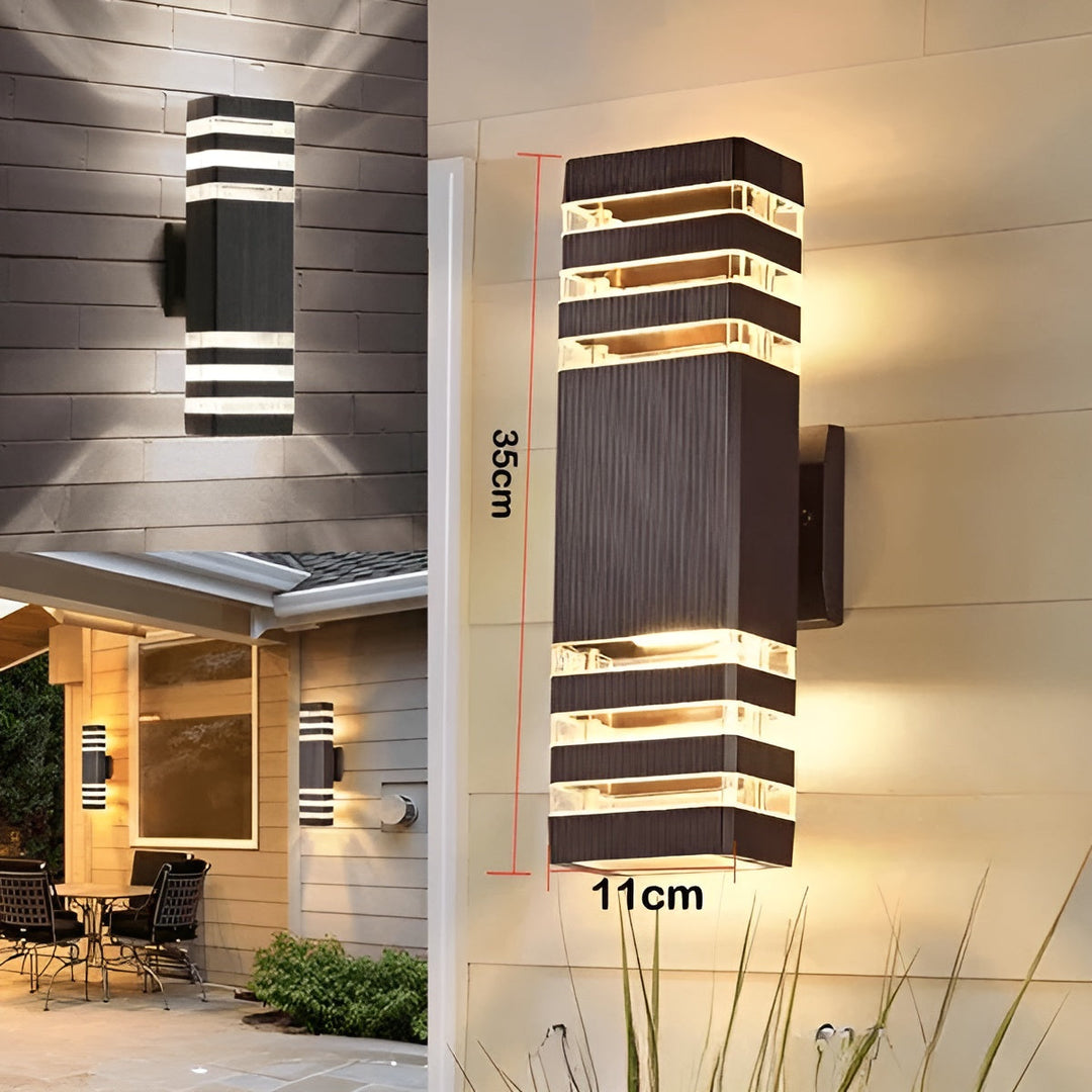 LED Outdoor Wall Light in black and transparent shown on a house wall with dimension markings.
