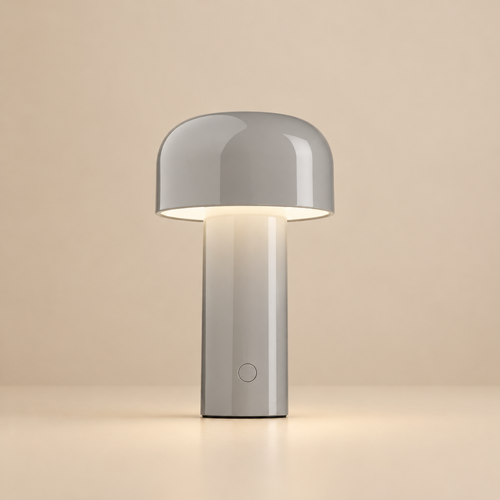 Glossy light gray lamp softly lit on a beige background, with a round button on the stem 32
