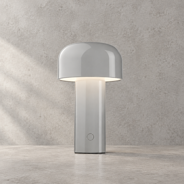 Glossy light gray lamp with round touch button, glowing under its dome shade 32