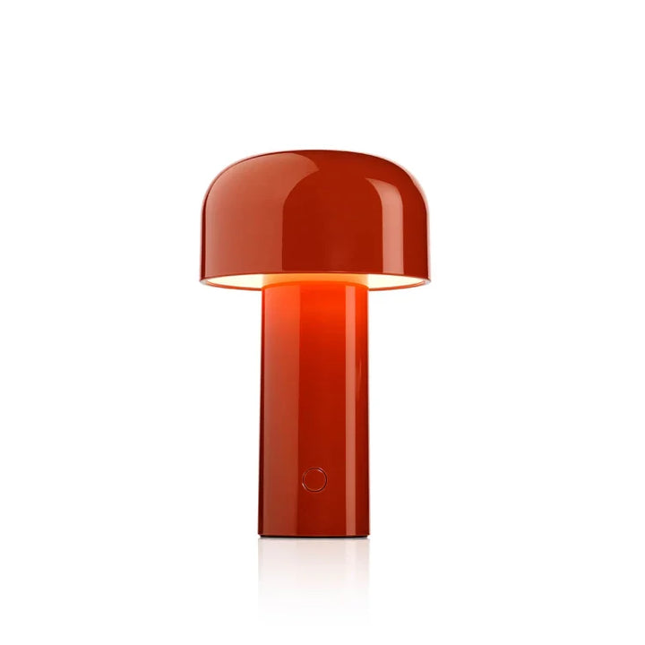 Glossy red-orange lamp lit from beneath its domed shade, shown on a plain white background 3