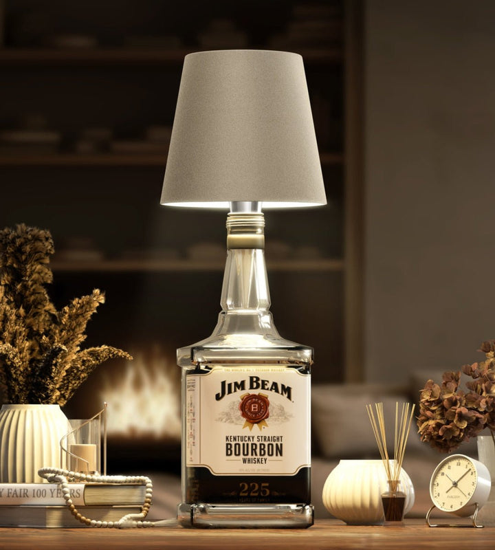 Taupe bottle lamp on a square bourbon bottle near a fireplace.