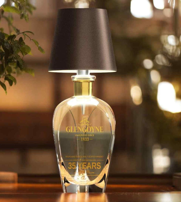 Dark brown bottle lamp on a clear crystal whisky decanter.